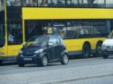 Smart next to a bus